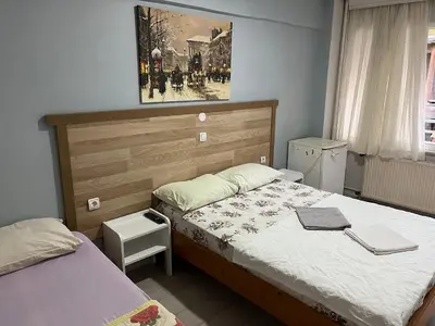 a bedroom with two beds and a painting on the wall at Çiğdem Motel Pansiyon & PUB in Termal