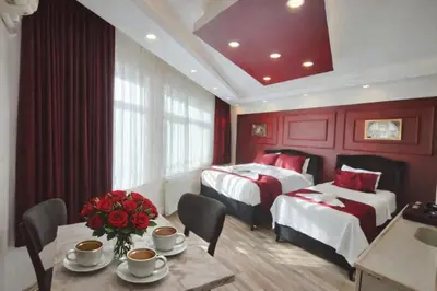 a hotel room with two beds and a table with roses at Valentina Apart Hotel in Istanbul