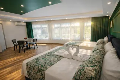 two beds in a hotel room with two swans towels at Valentina Apart Hotel in Istanbul