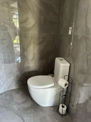 a bathroom with a white toilet in a stone wall at Kalimeras Deluxe Hotel in Sapanca