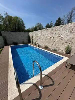 a swimming pool sitting next to a wooden deck at Kalimeras Deluxe Hotel in Sapanca
