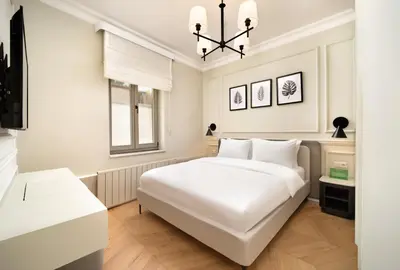 a white bedroom with a large white bed and a window at Vucino Suites in Istanbul