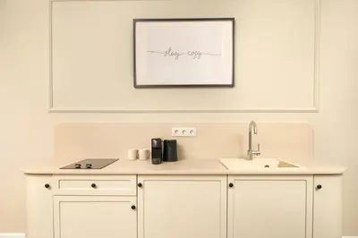 a kitchen counter with a sink and a picture on the wall at Vucino Suites in Istanbul