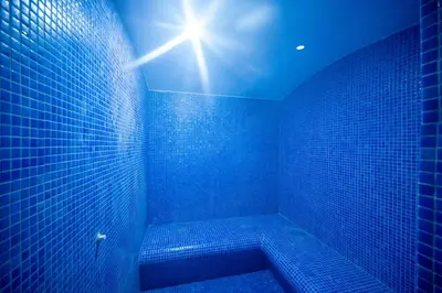 a blue tiled bathroom with a tub with a sun shining at Vess Hotel in Istanbul