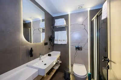 a bathroom with a sink and a toilet and a mirror at Vess Hotel in Istanbul
