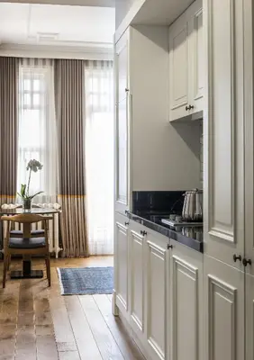 a kitchen with white cabinets and a table at Nevv Bosphorus Hotel & Suites in Istanbul