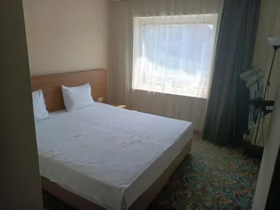 a bedroom with a large bed with a window at Helenapolis Otel in Yalova