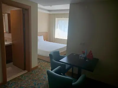 a hotel room with a bed and a table and chairs at Helenapolis Otel in Yalova