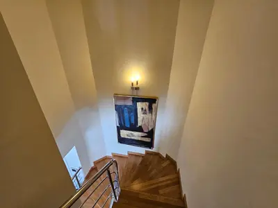 a hallway with a staircase with a painting on the wall at Taksim Perfect Residence, 3 bedrooms, pool, sauna, gym in Istanbul