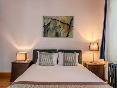 a bedroom with a bed with two night stands and two lamps at Historic Spacious Galata Apartment in Istanbul