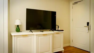 a flat screen tv on top of a white cabinet at Gaia Suites Istanbul in Istanbul