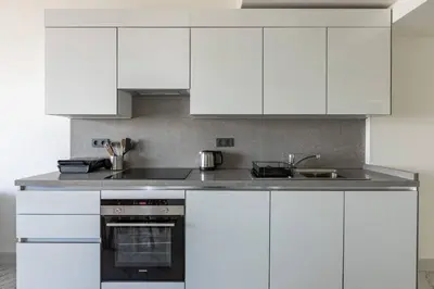 a white kitchen with white cabinets and a sink at Beautiful Bright 2Bed - ParkingPoolTerrace! #341 in Istanbul