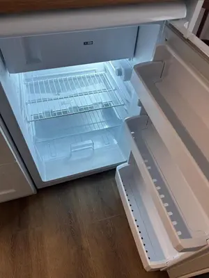 an empty refrigerator with its door open on a wooden floor at Yellowhouse Room 4 in Istanbul