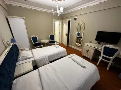 a hotel room with two beds and a television at Istanbul Allyon Hotel Taxim City Center in Istanbul