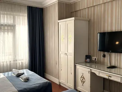 a bedroom with a bed and a cabinet and a television at Istanbul Allyon Hotel Taxim City Center in Istanbul