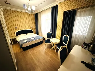 a bedroom with a bed and a table and chairs at Istanbul Allyon Hotel Taxim City Center in Istanbul