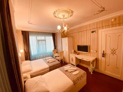 a hotel room with two beds and a desk at Istanbul Allyon Hotel Taxim City Center in Istanbul