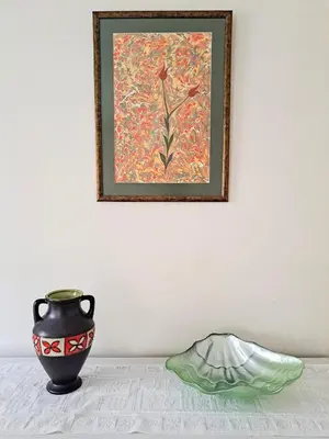 a vase sitting on a table next to a painting at Spacious and Bright Apartment - Dirim House in Istanbul