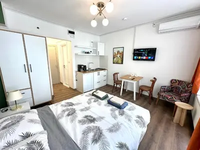 a bedroom with a bed and a table and a kitchen at Yellowhouse Room 6 in Istanbul