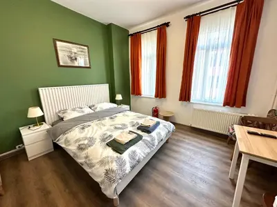 a bedroom with a bed with green walls and wooden floors at Yellowhouse Room 3 in Istanbul
