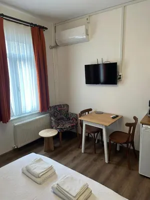 a living room with a table and a tv on the wall at Yellowhouse Room 3 in Istanbul