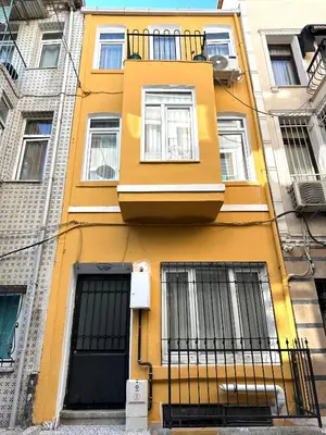 a yellow building with windows and a balcony at Yellowhouse Room 1 in Istanbul