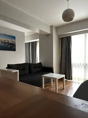 a living room with a black couch and a table at D&D Pansiyon in Istanbul