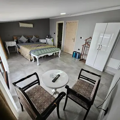 a bedroom with a bed and two chairs and a table at Bude Ortaköy in Istanbul