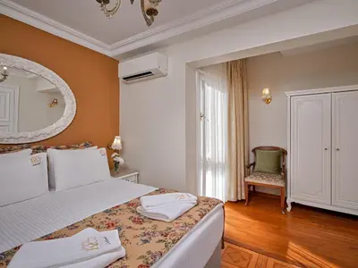 a bedroom with a bed with a mirror and a chair at 1207 Hotel Special Class Sultanahmet in Istanbul