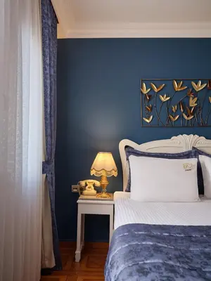 a blue bedroom with a bed and a table with a lamp at 1207 Hotel Special Class Sultanahmet in Istanbul