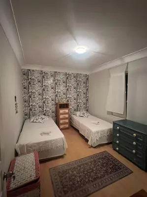 a small room with two beds and a dresser at Villa Elegance in Kocaeli
