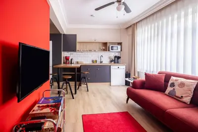 a living room with a red couch and a kitchen at AKA Home in Istanbul