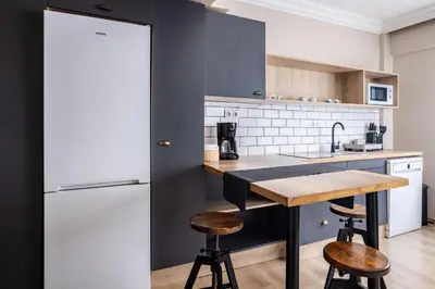 a kitchen with a white refrigerator and a wooden table at AKA Home in Istanbul
