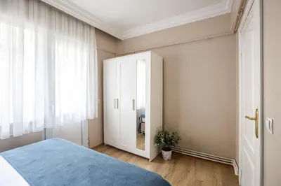 a bedroom with a blue bed and a cabinet at AKA Home in Istanbul