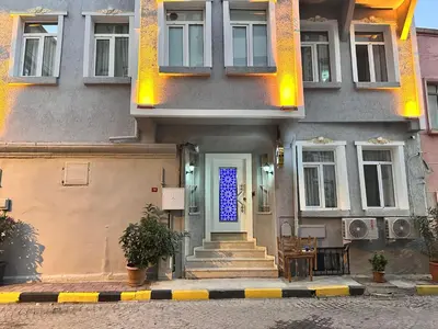 a house with a blue door and stairs at Hisar Çeşme Hotel in Istanbul