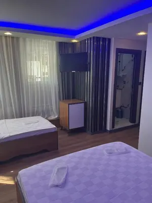 a bedroom with two beds and a tv on the wall at Hisar Çeşme Hotel in Istanbul