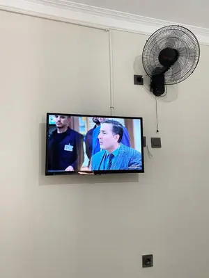 a flat screen tv hanging on a wall with a fan at Mimen Hostel in Istanbul