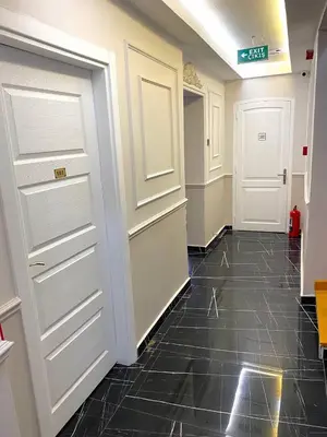 a hallway with white doors and a black tile floor at Mimen Hostel in Istanbul