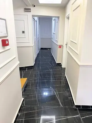 a hallway with a black tile floor and a door at Mimen Hostel in Istanbul