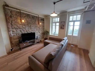 a living room with a couch and a stone wall at Stone Garden Apartment in the Heart of the City in Istanbul