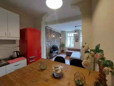 a kitchen with a wooden table and a red refrigerator at Stone Garden Apartment in the Heart of the City in Istanbul
