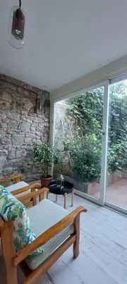 a living room with a couch and a large window at Stone Garden Apartment in the Heart of the City in Istanbul