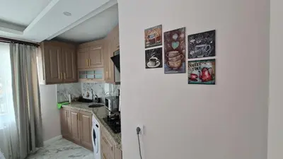 a kitchen with wooden cabinets and a refrigerator at Cozy Duplex Next to Green Masjid in Yıldırım