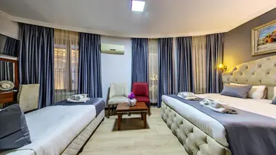 a hotel room with two beds and a chair at Hotel Mara İstanbul in Istanbul