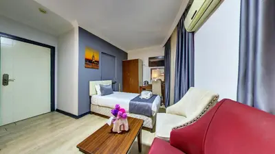 a hotel room with a bed and a red couch at Hotel Mara İstanbul in Istanbul