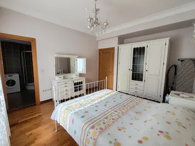 a bedroom with a bed and a dresser at Garden Floor Flat in a Beachfront Complex with a Pool in Gümüşyaka