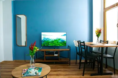 a blue room with a table and a television at Beans House Suite 8-26 in Istanbul