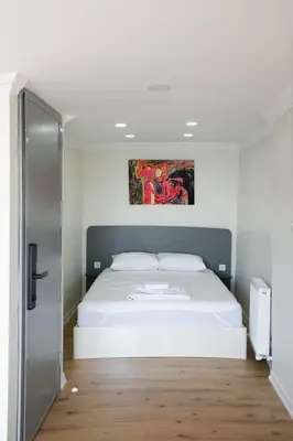a bedroom with a white bed and a painting on the wall at Beans House Suite 8-26 in Istanbul