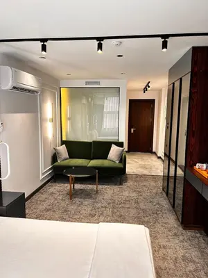 a living room with a green couch and a table at Zeytin Hotel in Istanbul