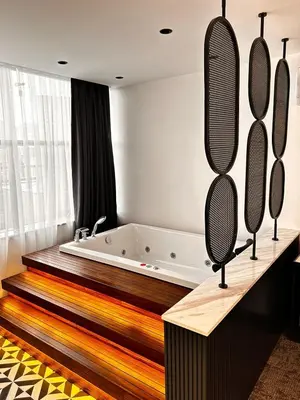 a bathroom with a bath tub and a large mirror at Zeytin Hotel in Istanbul